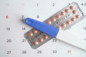 gravidez teste e nascimento ao controle pílulas em calendário, contracepção saúde e remédio. foto