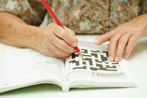 idosos mulher jogando sudoku enigma jogos para tratamento demência prevenção e alzheimer doença. foto