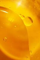 ouro óleo bolhas fechar acima. círculos do laranja água macro. abstrato brilhante amarelo fundo foto