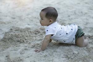 ásia criança pequena bebê tailandês menina jogando com areia foto