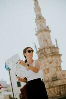 fêmea turista com cidade mapa de a santo Oronzo estátua dentro ostuni, Itália foto