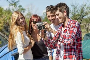 grupo do jovem adulto assistindo fotos em digital Câmera