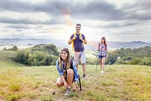 grupo do jovem caminhantes caminhando em direção a a horizonte sobre a montanha foto