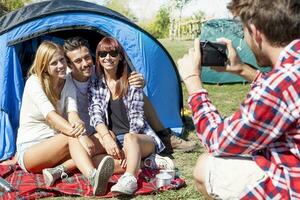 grupo do amigos em período de férias leva fotos às a acampamento