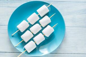 marshmallow espetos em a prato foto