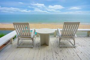 branco madeira de praia cadeira perto mar dentro verão. foto