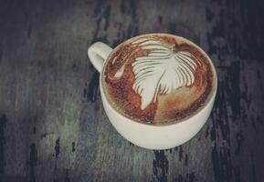 café café com leite arte em a de madeira escrivaninha foto