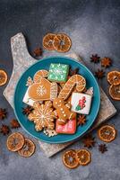 lindo delicioso doce inverno Natal Pão de gengibre biscoitos em uma cinzento texturizado fundo foto