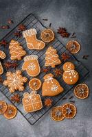 lindo delicioso doce inverno Natal Pão de gengibre biscoitos em uma cinzento texturizado fundo foto