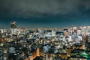 Visão do arranha-céu construção com brilhando luz dentro metrópole cidade foto