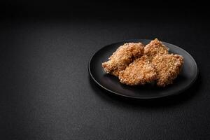 deliciosos nuggets de frango crocantes frescos em um fundo escuro de concreto foto