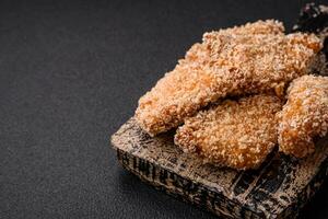 deliciosos nuggets de frango crocantes frescos em um fundo escuro de concreto foto