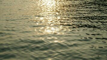 ondulações em a água superfície do a mar, pôr do sol cores, topo Visão foto