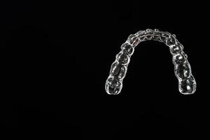 invisível alinhador dentes retentores em uma Preto fundo foto