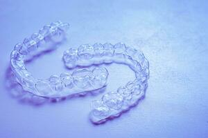 invisível alinhador dentes retentores em uma azul fundo foto