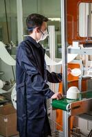 uma homem trabalho às uma máquina para a fabricação do médico máscaras com nanofibra. coronovírus e covid-19 prevenção foto