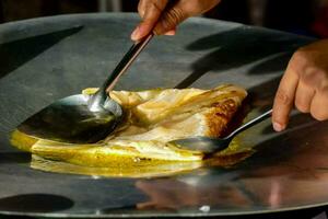 uma pessoa é cozinhando uma panqueca dentro uma panela foto