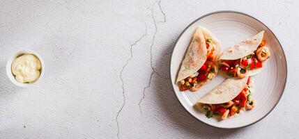 suave Aperitivo mini tacos com camarão, tomates e ervas em uma prato topo Visão rede bandeira foto