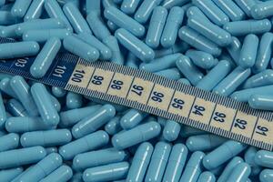 azul peso perda pílulas e medindo fita simbolizando emagrecimento foto