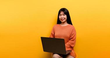 Mulher asiática e laptop e estão felizes em trabalhar foto