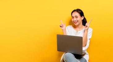 mulher asiática trabalhando em seu laptop e com um sorriso feliz foto