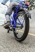 uma criança dentro uma capacete e proteção dentro uma bicicleta passeio em natureza dentro a Primavera foto