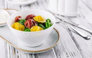 cozinhou multicolorido tortellini dumplings fechar-se dentro uma tigela foto