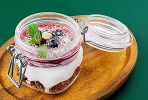 granola com nozes, iogurte e frutas bagas dentro uma jarra foto