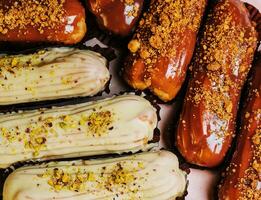 tradicional francês eclairs com chocolate e baunilha creme e copo do espresso foto