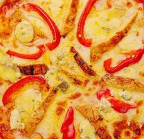 uma topo Visão do brega frango pizza com fatiado vermelho Sino Pimenta foto