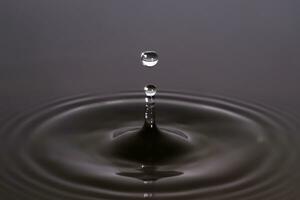 água gotas batendo a limpar \ limpo superfície do a água fechar-se. foto