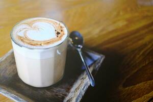 copo do quente café em a velho de madeira bandeja foto