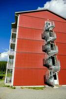 uma espiral Escadaria em uma vermelho construção foto