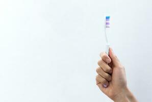 mão segurando uma escova de dente em gradiente fundo. depois de alguns Editar% s. foto