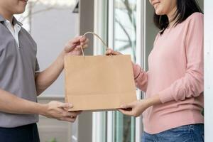 feliz sorridente mulher recebe caixas parcela a partir de correio dentro frente casa. Entrega homem mandar entregar expressar. conectados compras, papel containers, remover, carteiro, Entrega serviço, pacotes foto