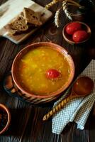 ervilha sopa com tomate em uma de madeira mesa. tomate sopa com Chucrute tomates e uma de madeira colher. esloveno nacional prato. foto