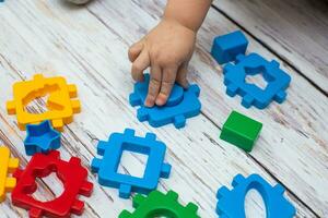 mão do criança colocando verde açao figura dentro bebê blocos forma classificador brinquedo. educacional Ordenação Coincidindo brinquedo para crianças foto