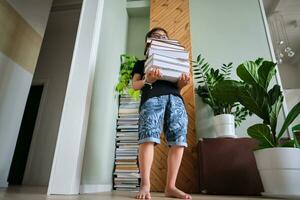 uma Garoto detém uma pilha do livros contra a fundo casa biblioteca. foto