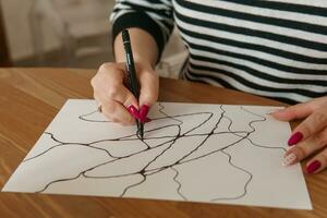 tver, Rússia - fevereiro 25, 2023. mulher desenha neurografia às mesa às uma psicológico sessão, neurográfico lápis desenhando para retirar restrições, arte terapia foto