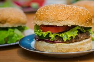 dois caseiro hamburguer com tomate e carne empada, fresco coberturas em todo grão artesão pão em cozinha mesa para jantar foto