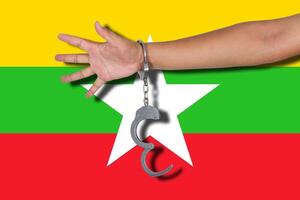 algemas com mão na bandeira da myanmar foto
