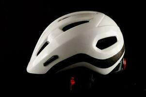 uma branco bicicleta capacete em uma Preto fundo foto
