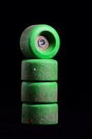 uma pilha do verde skate rodas em uma Preto fundo foto