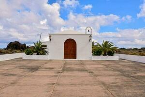 uma branco Igreja com uma de madeira porta e Palma árvores foto