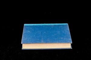 uma azul livro em uma Preto fundo foto