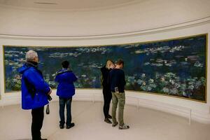 pessoas olhando às água lírios dentro uma museu foto