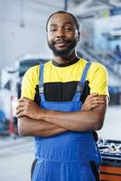 retrato do orgulhoso bipoc reparador dentro auto reparar fazer compras encarregado com mudando carros freio fluido. qualificado especialista dentro garagem pronto para começar fazendo checkups em veículos dentro garagem área de trabalho foto