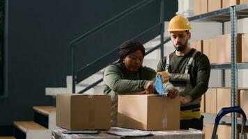 homem vestindo capacete de segurança dentro armazém entrega Fora cartão caixas para africano americano Gerente selagem pacotes. armazenamento estabelecimento pessoal protegendo parcelas para evitar problemas durante Entrega foto