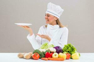 fêmea chefe de cozinha cercado com legumes segurando placa. foto