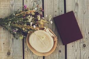 lindo ramalhete do flor, livro e chapéu em de madeira mesa foto
